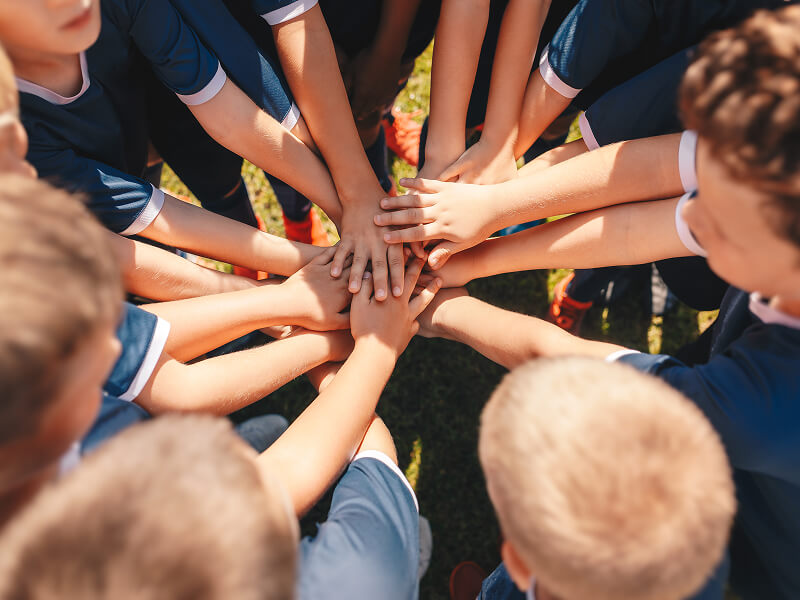 手を重ねる子どもたち